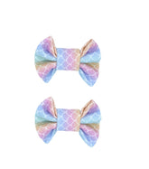 A set of two mermaid print bow clips for toddler girls from By Bella Boutique.